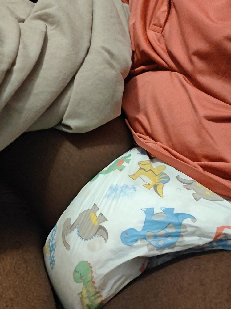 Laying on my bed in my very soaked soggy diaper.