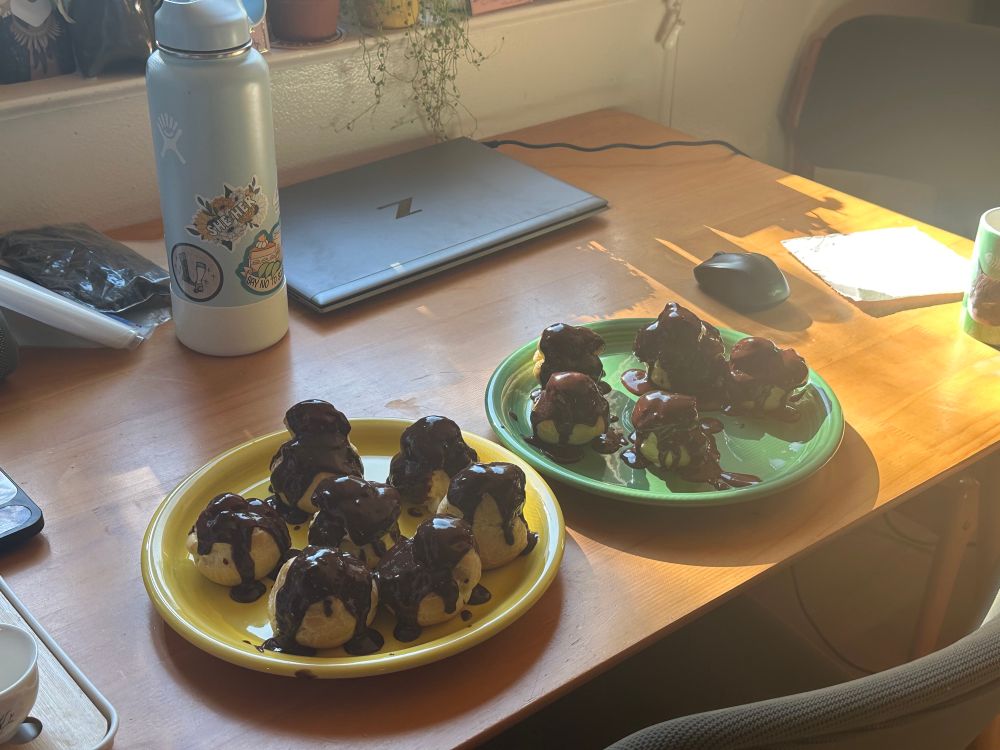 Two plates with profiteroles on a table 