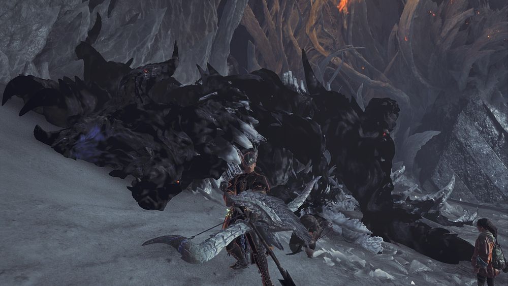 An image of the monster, Zoh Shia, from the game Monster Hunter Wilds, lying on the ground, defeated as the hunter poses with a bow in front of it. 