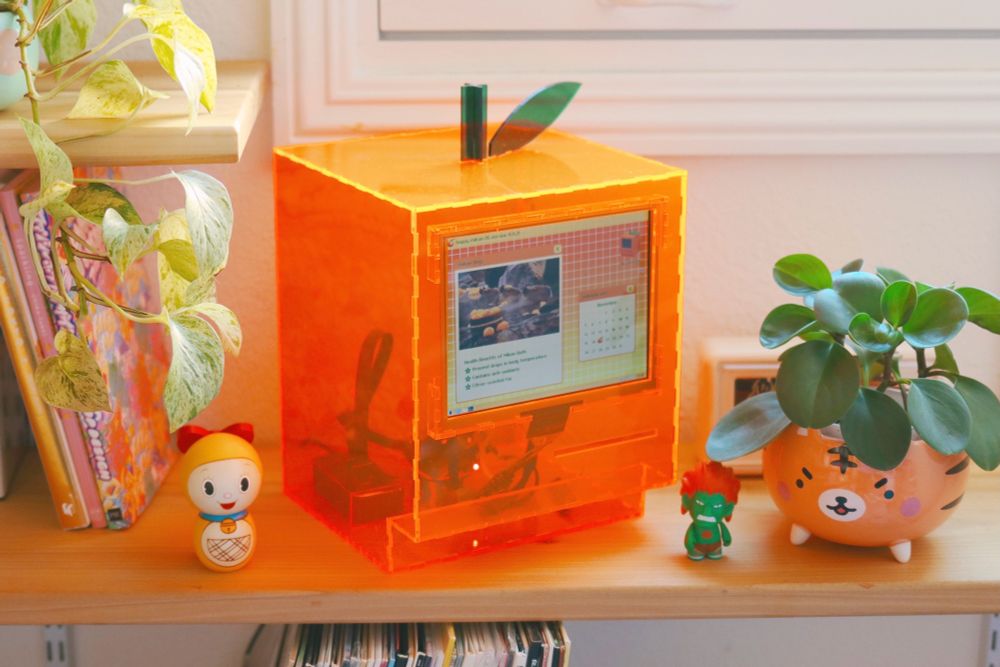mikan shaped computer on a bookshelf with tiger planter and doremi figure 