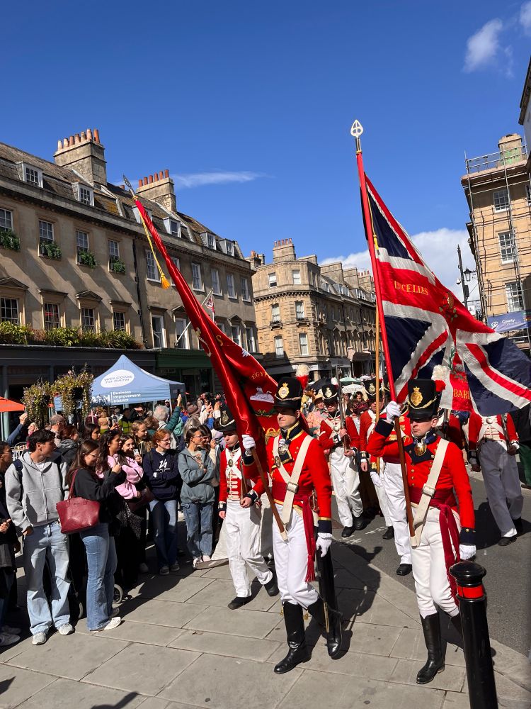 The redcoats are coming as regency era army soldiers march through Bath past onlookers and bemused tourists.