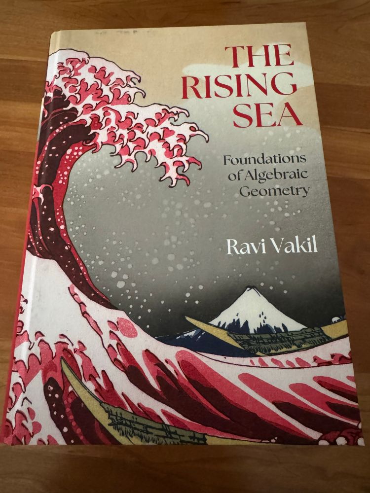 A hardcover copy of “The Rising Sea: Foundations of Algebraic Geometry” by Ravi Vakil, with cover art featuring a red take on the painting “The Great Wave off Kanagawa”