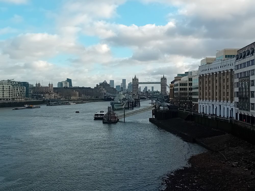 View of the Thames from London Bridge, a smidgen of blue sky above. Ship HMS Belfast visible, Tower Bridge in background