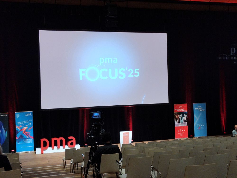 Foto von der Bühne des pma focus 2025 mit einemr großen Leinwand, die den Namen des Events zeigt.