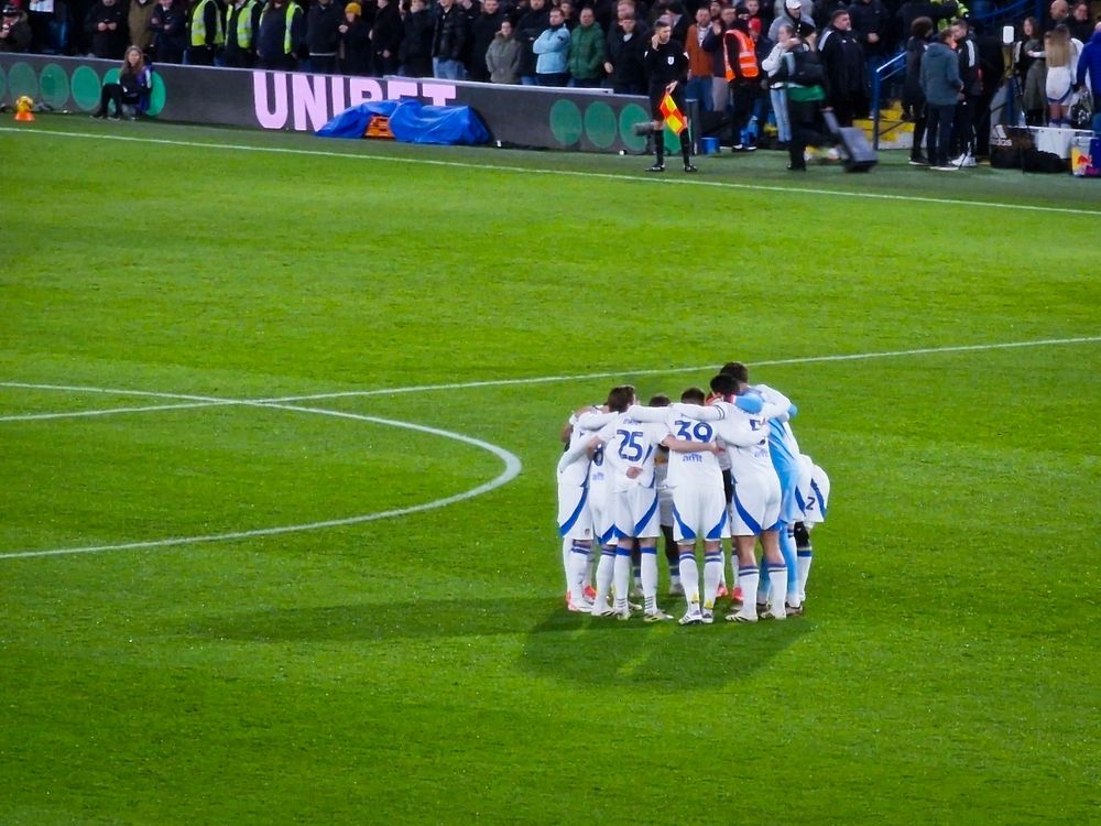 Leeds united team having a huddle before the game