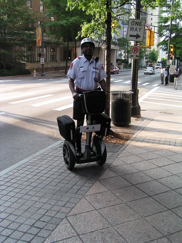 Ein amerikanischer Polizist in kurzer Hose und kurzärmeligem Hemd, auf einem Segway.