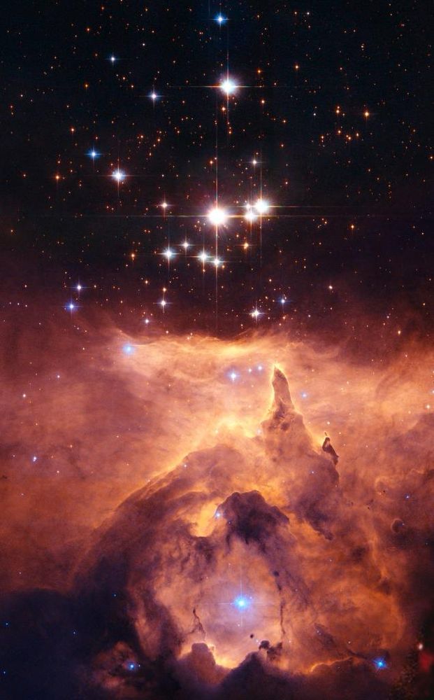 The star cluster Pismis 24 lies within the much larger emission nebula called NGC 6357, located about 8,000 light-years from Earth. The cluster is seen here above a small portion of the nebula. The gas below the stars glows through ionization caused by intense ultraviolet radiation from the massive young stars within the cluster. The strong radiation and stellar winds from from these blazing, blue-white stars also pushes the nebular material outward, creating one of many low-density bubbles within NGC 6357.