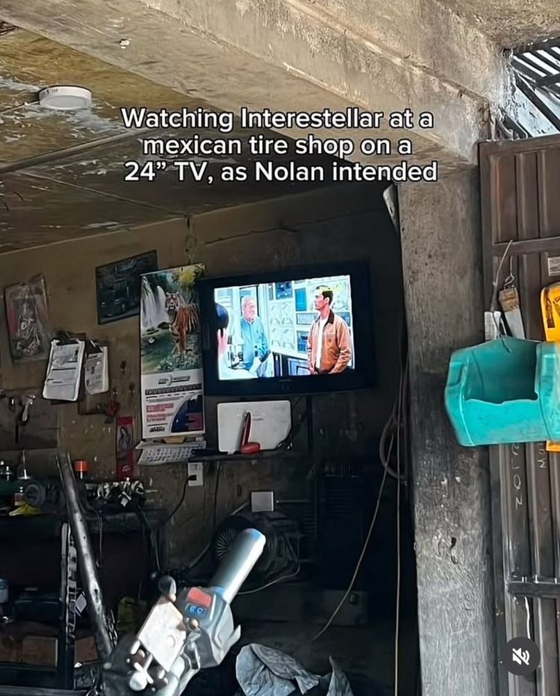 A picture of a small tv in a shop with white text reading: “Watching Interstellar in a Mexican tire shop on a 24” TV as Nolan intended.”
