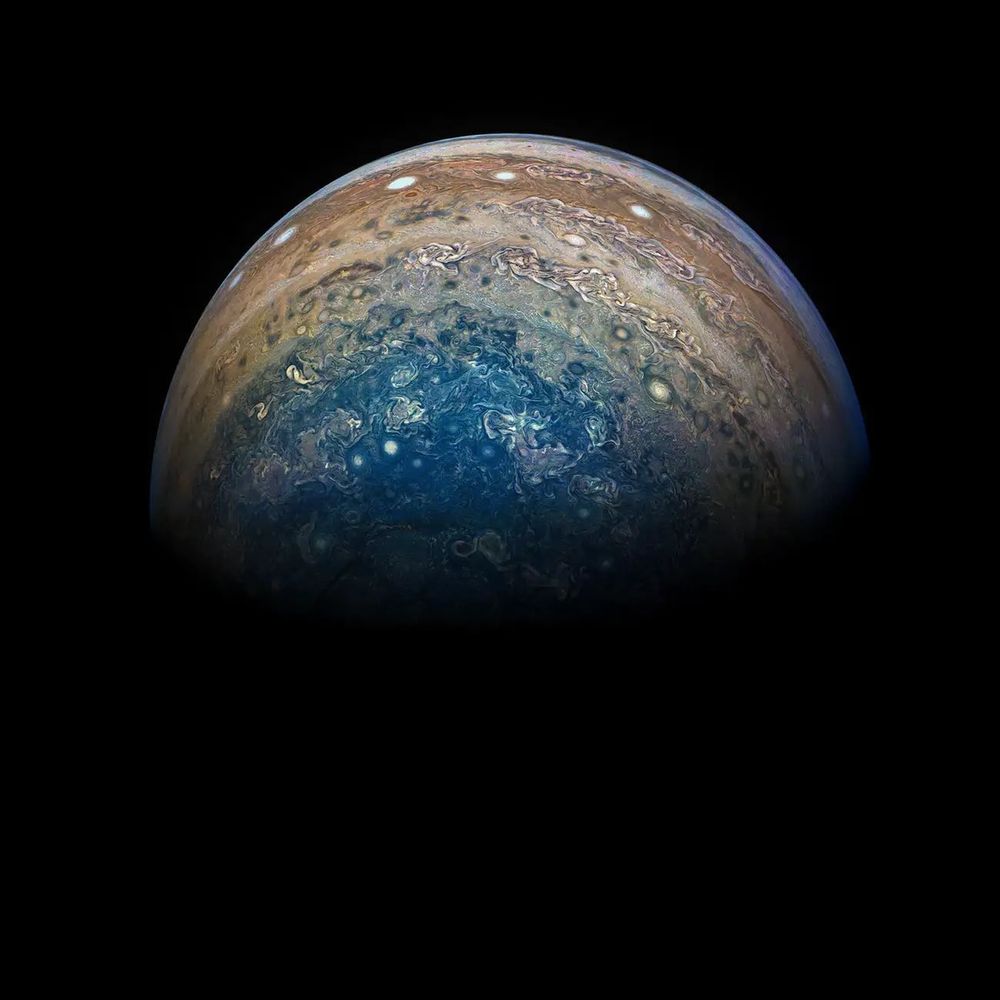 A view taken of one of Jupiter’s polar regions. Swirling cloud formations can be seen in hues of blue, white, and orange.

Processing: Gerald Eichstadt/@_TheSeaning