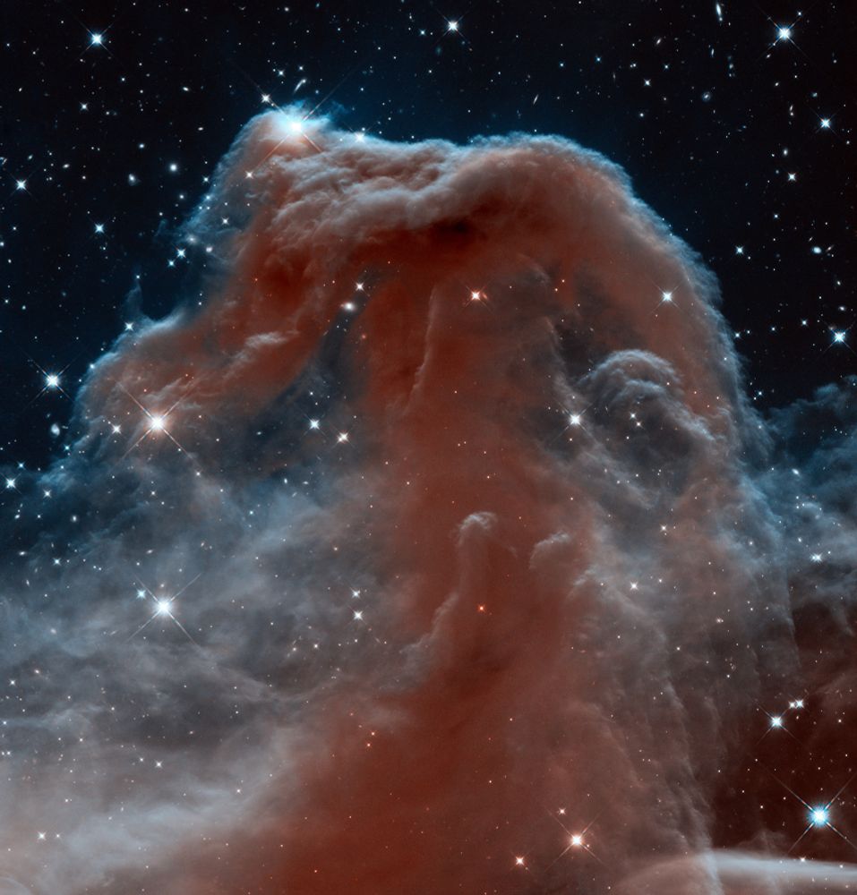 A massive cloud of gas and dust is seen in dark, dusty red, with its outer portions a translucent, ethereal gray. Several stars and distant galaxies are scattered throughout the image.