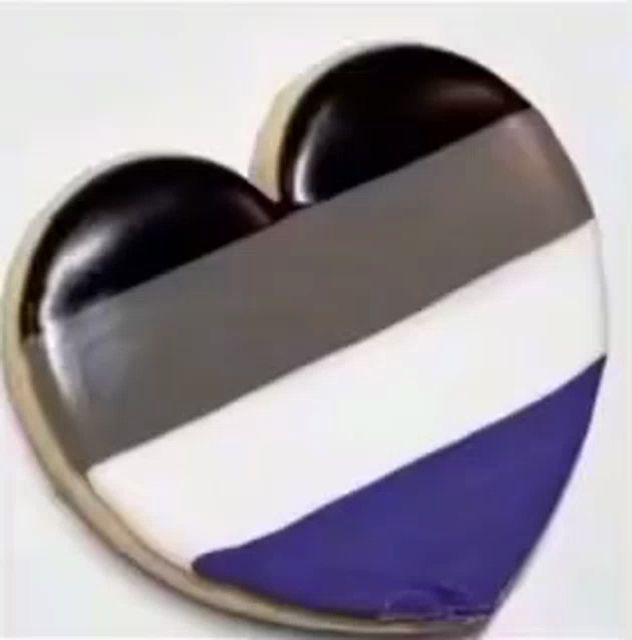 a heart shaped button with a gray , white and blue flag on it .