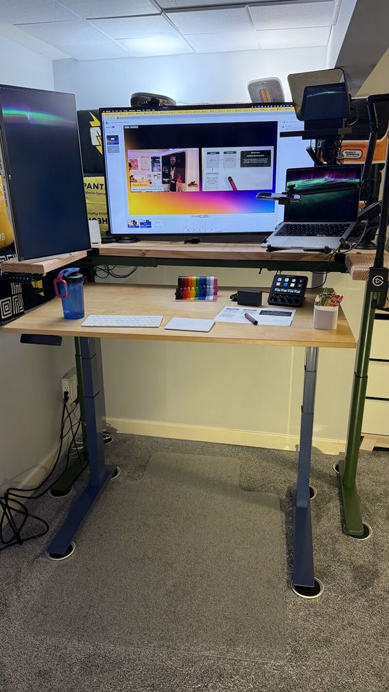 A regular standing desk with another standing desk behind it to hold all the monitors and stuff