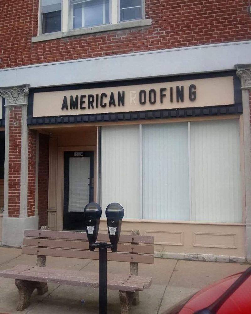 A business sign for American Roofing missing the 'R' in the word Roofing, so now reads American oofing. 