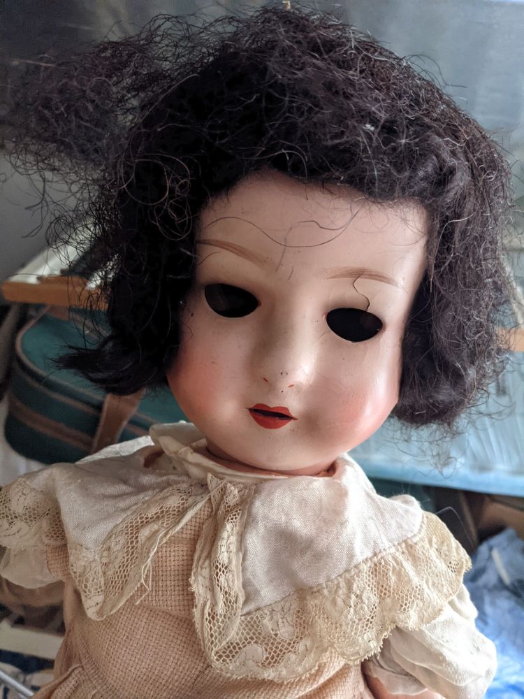 A vintage doll with empty, staring eye sockets as black as the everlasting void, and a single crazed crack over one eyebrow.