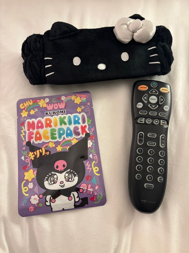 A black hello kitty headband, narikiri kuromi face pack and remote.