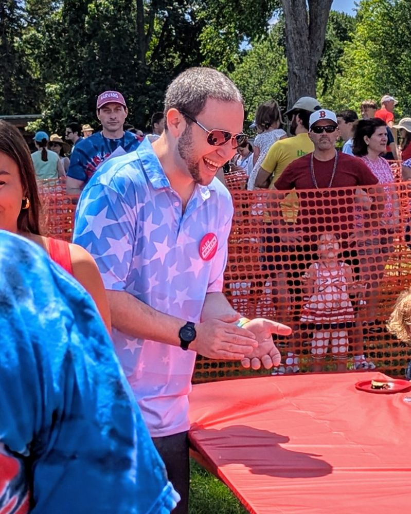Alex smiling and clapping while cheering on participants