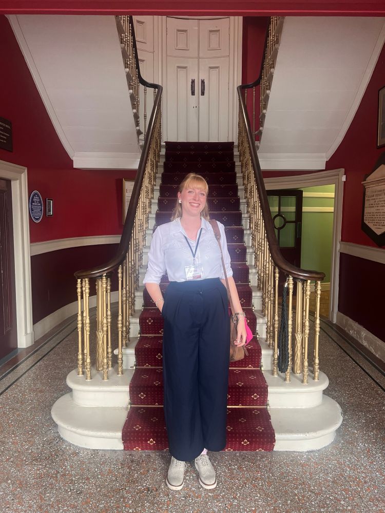 Woman stood in front of some stairs with red carpet 