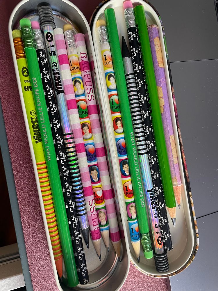 Pencil case showing a selection of old pencils, including yikes, bagpuss, and one direction ones. 