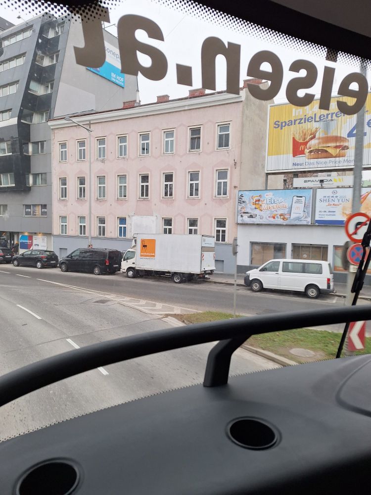 Blick aus dem Bus in Wien. Häuser, Autos.