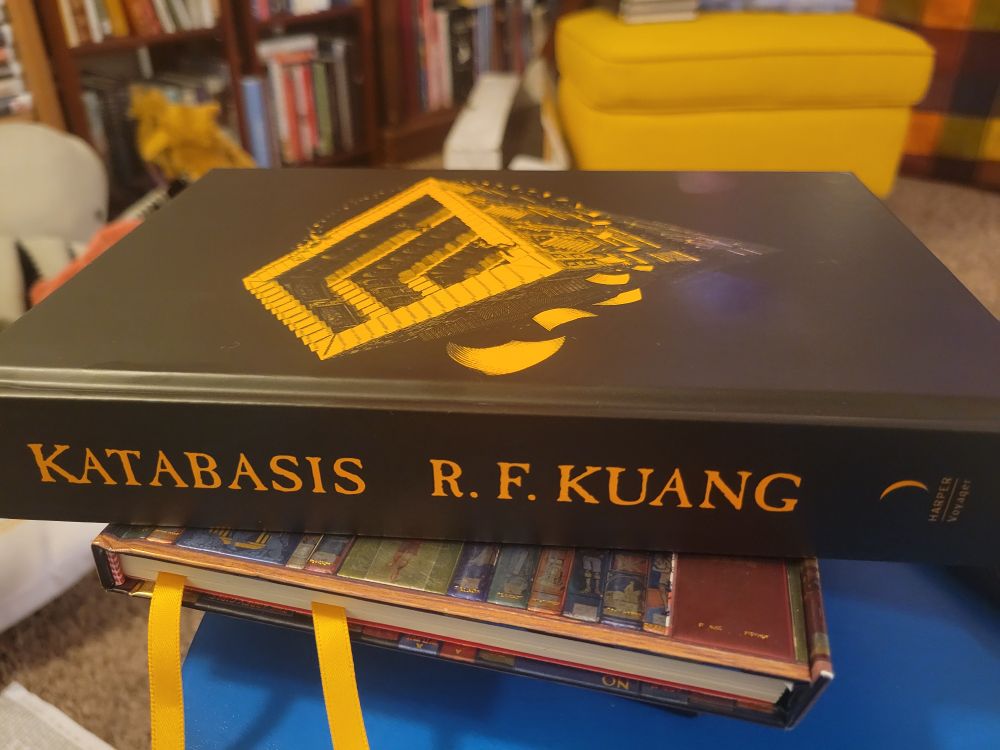 Katabasis by RF Kuang book sitting on another book on a blue stool