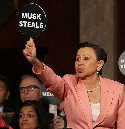A member of Congress holds a paddle that says 