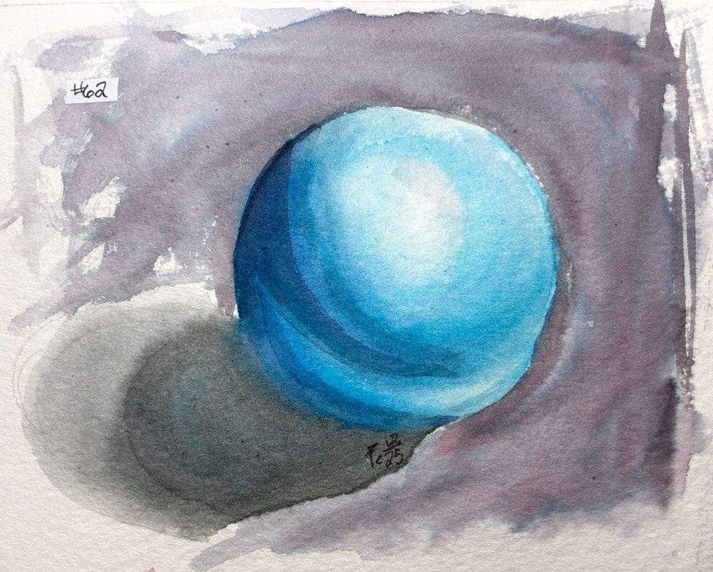 An ink wash illustration of a slightly lumpy blue sphere. The artist's signature "Fc12/25" is in the ball's shadow, and the title "#62" is in black ink on white correction tape in the top left corner.