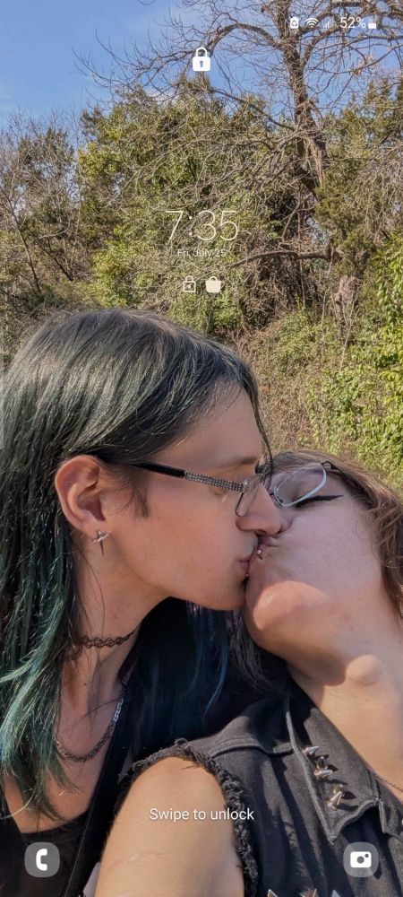A screenshot of Erika's phone lockscreen featuring a picture of Erika kissing her girlfriend Xaty on the mouth. The clock reads 7:35 Fri, July 25. The battery is 55% charged.