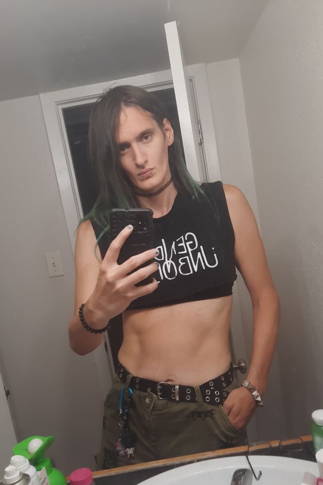 Erika wearing a black crop top and brown short shorts 