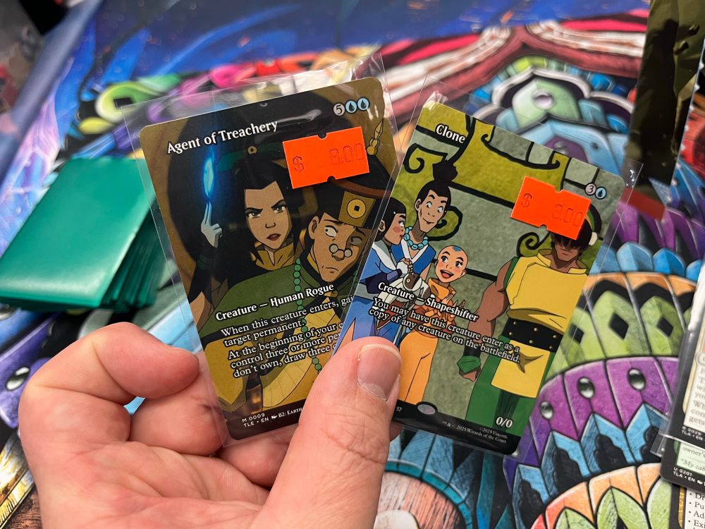 My hand holding a copy of the Avatar versions of Agent of Treachery and Clone.