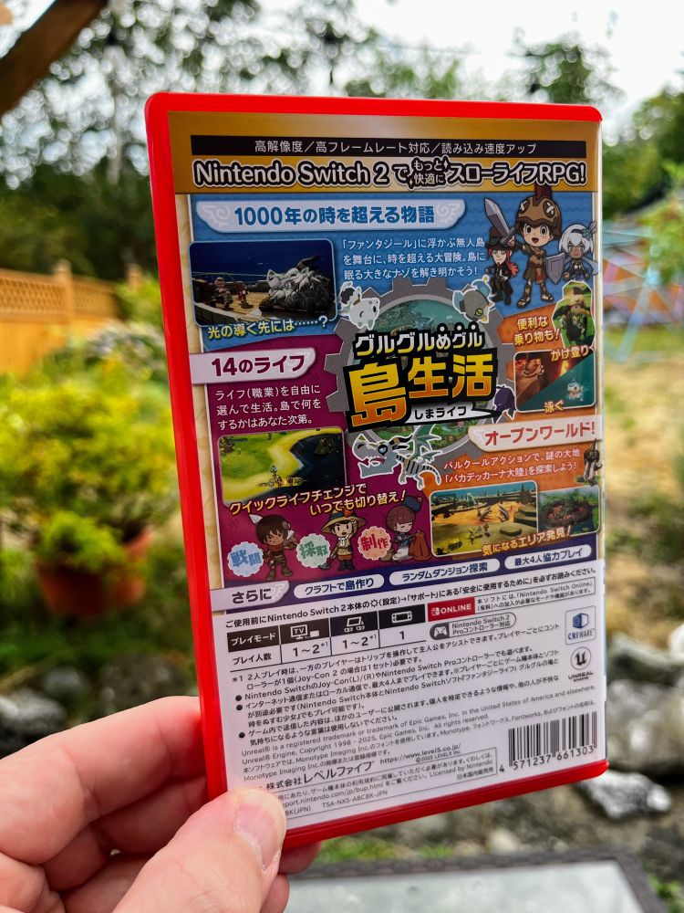 My hand holding a physical Japanese copy of Fantasy Life i for the Switch 2, showing off the back of the case.