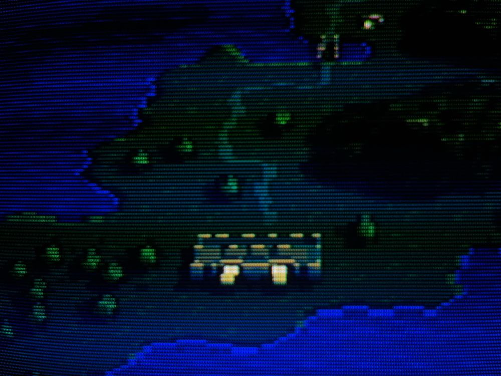 A photograph of Ogre Battle: March of the Black Queen on a CRT. A medieval island at night.