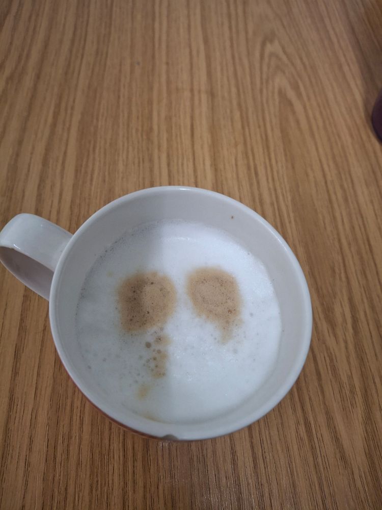Cappuccino with two dark patches that look a bit like cursed or haunted eye sockets. 