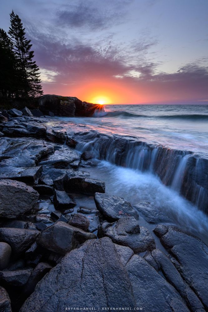 Sunrise over a rocky basalt shoreline and Lake Superior.