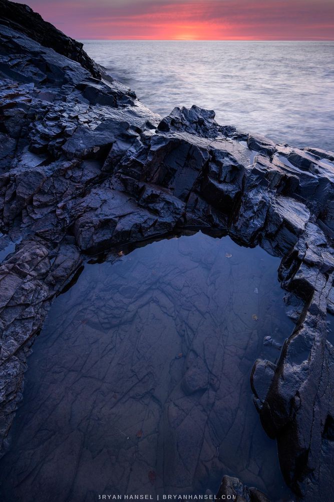 Sunrise over a rocky basalt shoreline and Lake Superior.