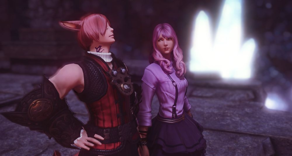 Photo of Nayzak and G'raha standing side by side. G'raha is looking up at the sky with his hands on his hips, while Nayzak is turning her head to the side to look at G'raha.