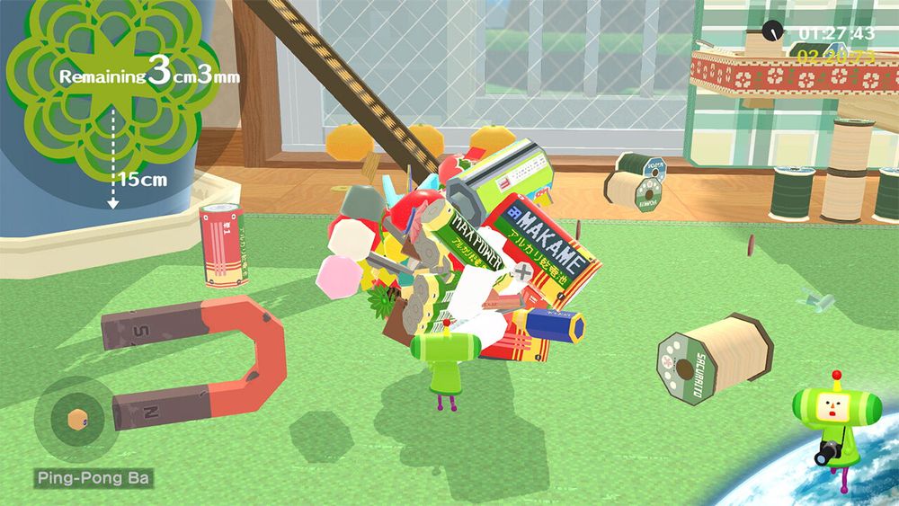 A little guy from the video game Katamari Damacy rolls around a ball made up of items he’s collected from around the room.