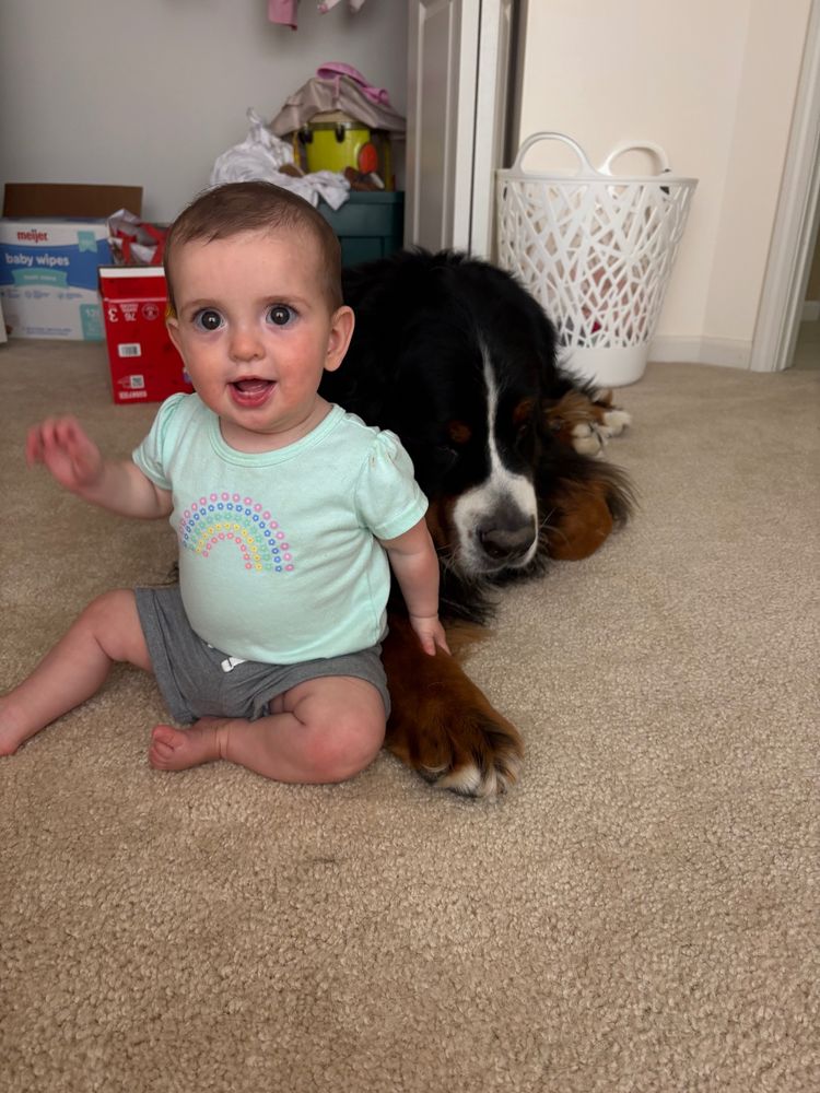 Tiny baby leaning against giant floof 