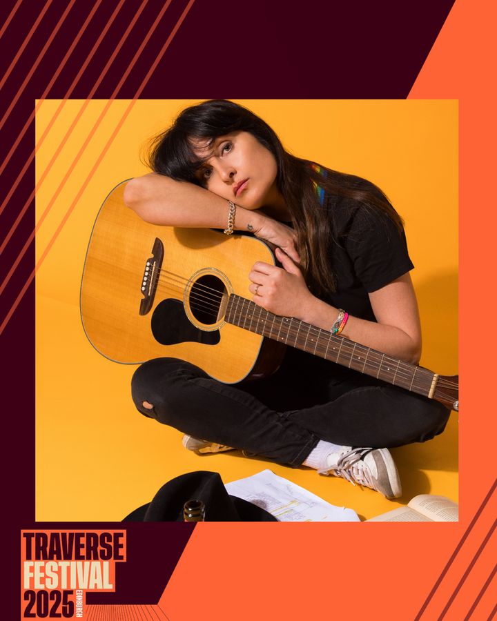 Young woman seated against a vibrant yellow background, cradling an acoustic guitar with a pensive expression. Text reads "Traverse Festival 2025."