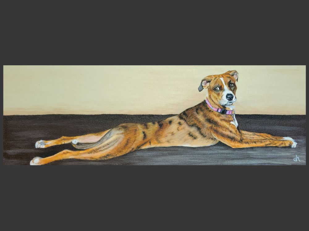 An acrylic painting on a 6x18 stretched canvas. The painting is a dog, light brown to orange in color with subtle black stripes in its fur. The dog is laying on the ground, fully stretched out with its legs stretched out all the way behind it. The dog is looking over its shoulder, giving a side eye of caution. The dog is wearing a pink collar. 