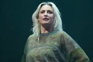 Nova Vocalista do Link Park, Emily Armstrong. Mulher loira de pele branca vestindo uma camisa de manga longa verde quanto olha para frente, na direção de quem bateu a foto.