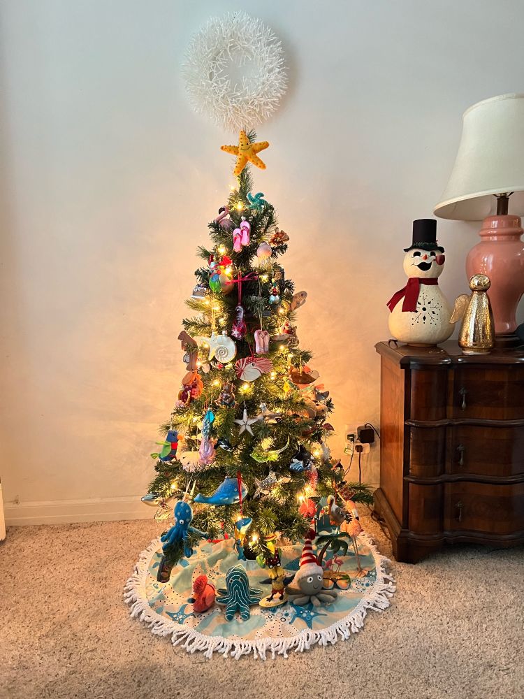 Small Christmas tree with ocean themed ornaments and a sea star on top.