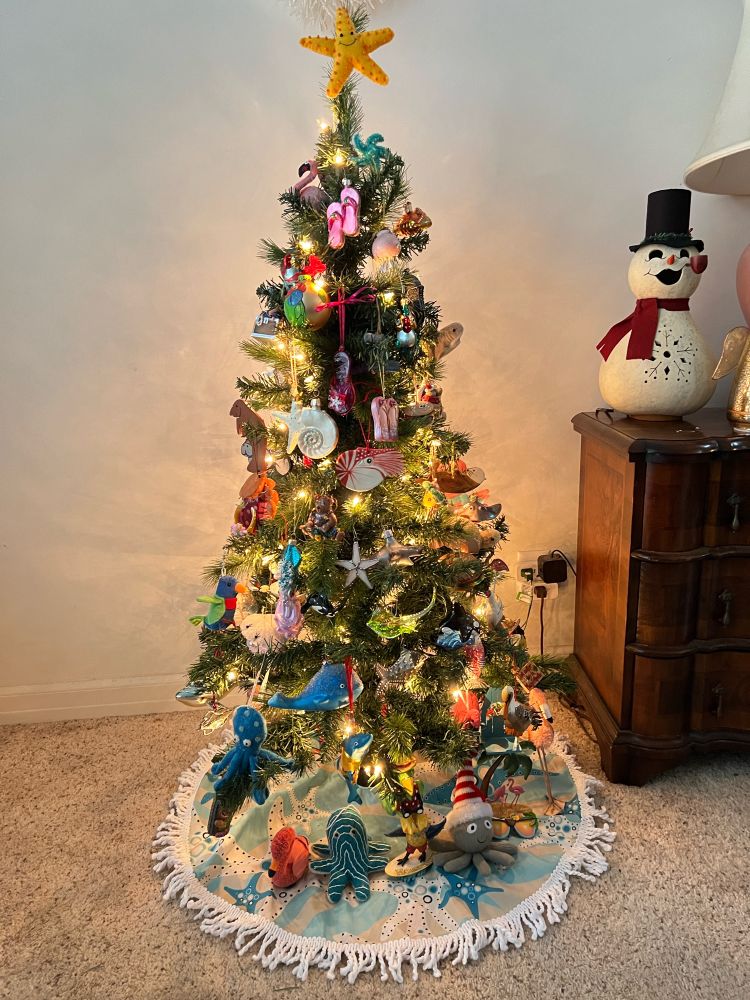Small Christmas tree with ocean themed ornaments and a sea star on top.