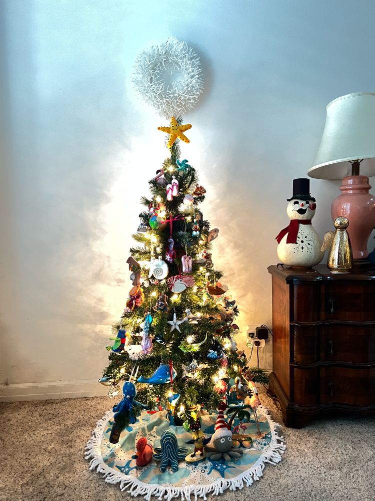 Small Christmas tree with ocean themed ornaments and a sea star on top.