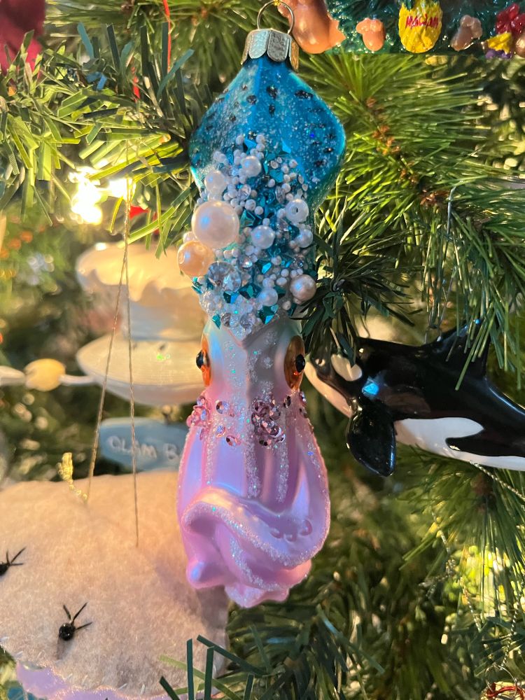 Photo shows a sparkly blue and pink squid Christmas ornament.