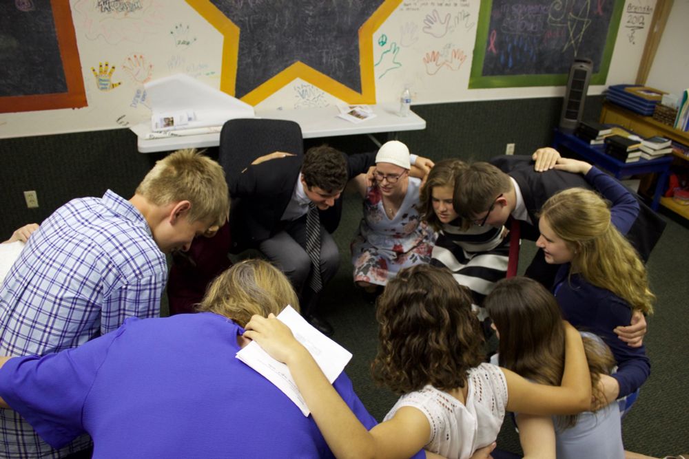 [Confirm Not Conform students gather for a "Zap prayer" before they preach at the confirmation service.]