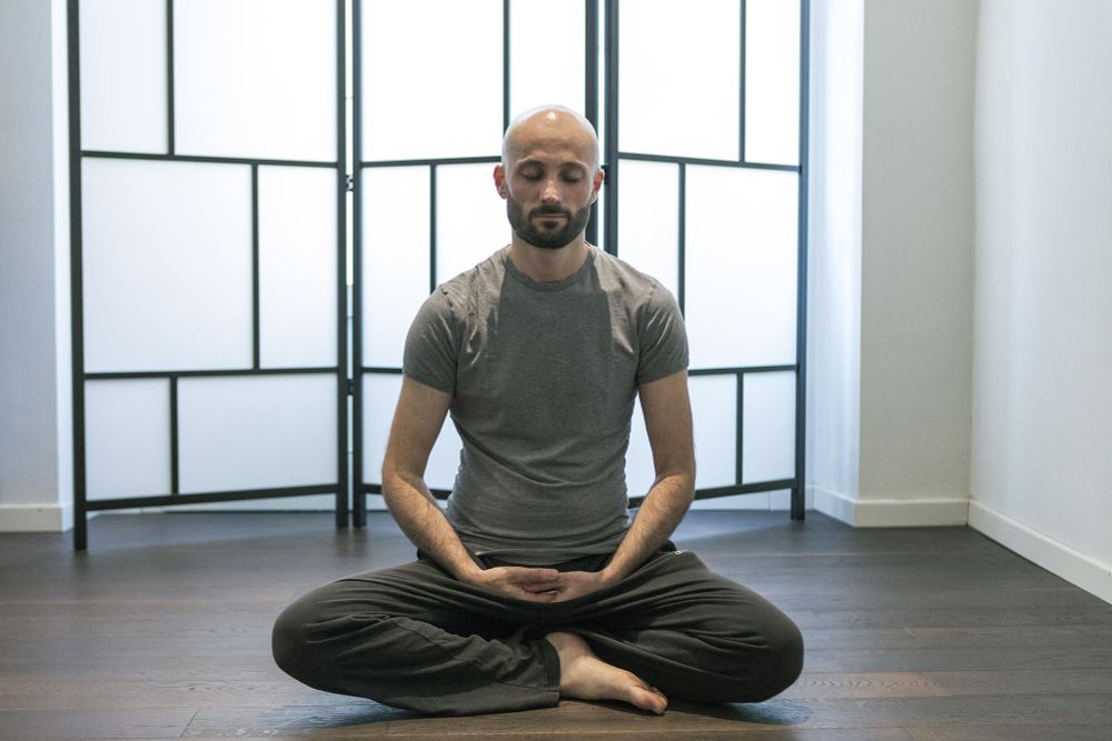 Uomo la gamba incrociate in posizione da meditazione.
