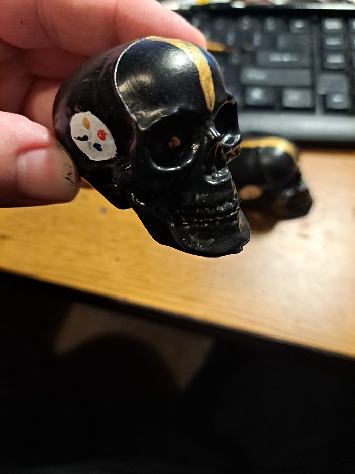 A black skull painted like a Pittsburgh Steelers helmet.