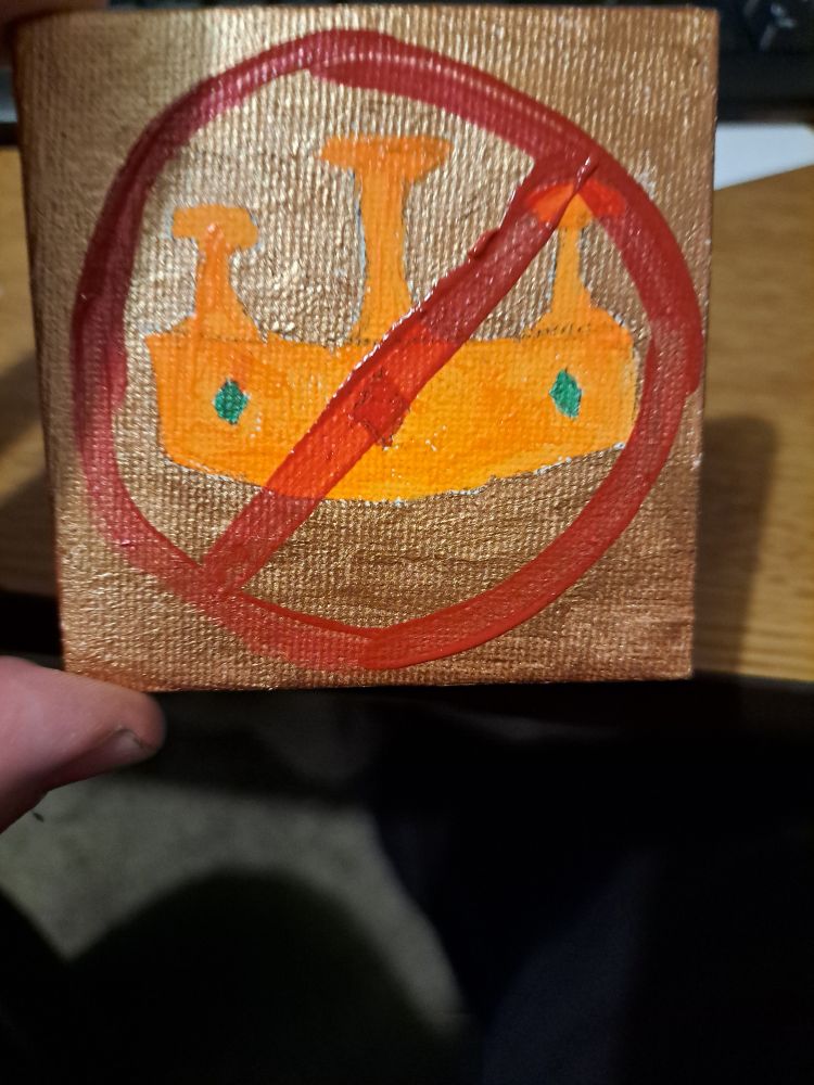 An orange crown with mushroom accouterments on a gold background surrounded by a red circle with a red diagonal line through it.