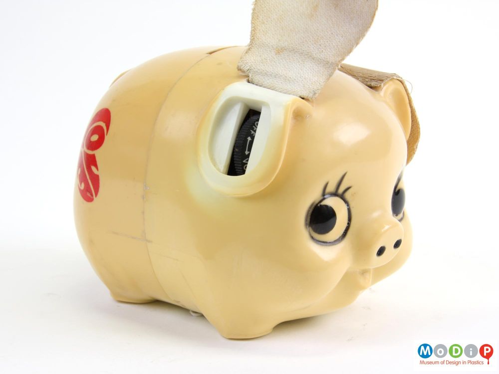 A pig shaped radio with big eyes and its ear up showing the radio dial.