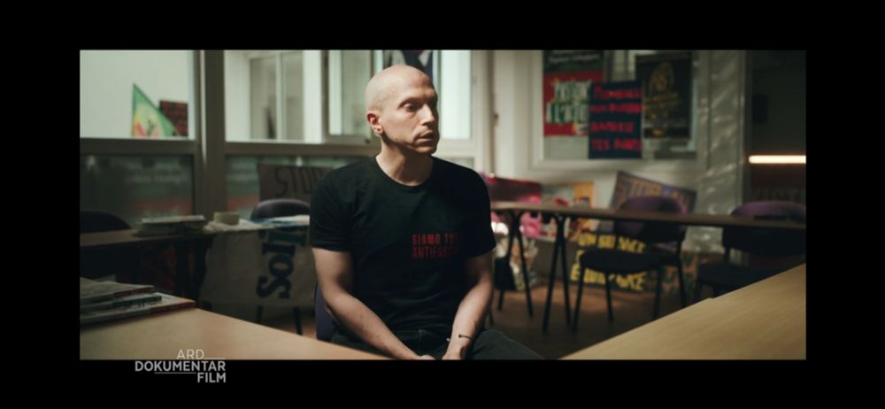 Un homme chauve portant un t-shirt avec écrit en rouge "Siamo Tutti Antifascisti"